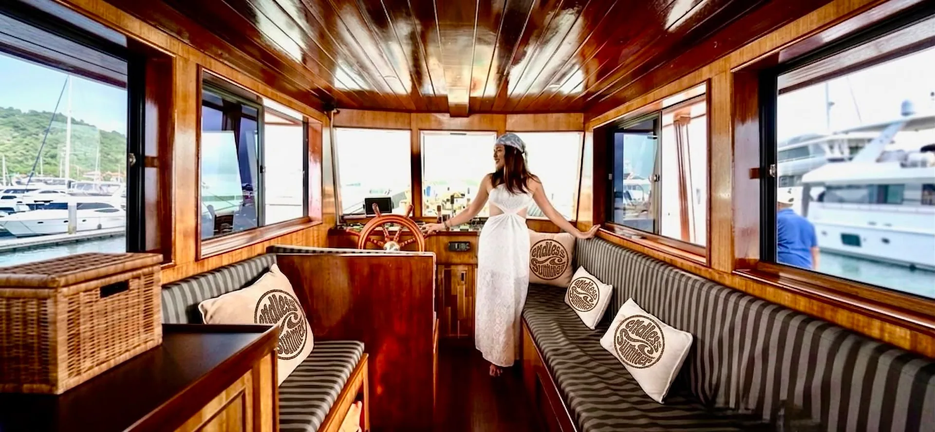 Handcrafted teak cabin interior of the Endless Summer Thai teak cruiser with striped cushioned lounges